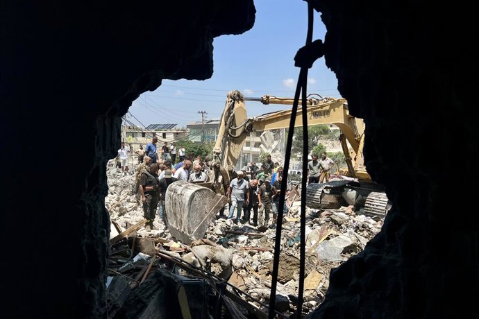 DEIR AL ZAHRANI, 15 de agosto de 2026  -- Equipes de resgate vasculham os escombros de prédios atingidos por ataques aéreos israelenses em Deir Al Zahrani, no sul do Líbano, em 15 de agosto de 2026. A emissora libanesa Al-Jadeed TV informou que quatro pes
