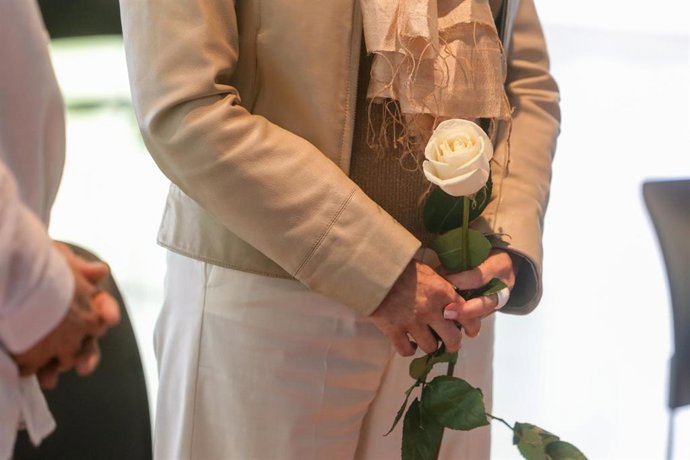 Archivo - Detalle de una de las contrayentes sujetando una rosa blanca durante la celebración de su boda. En Madrid, (España), a 13 de junio de 2020.