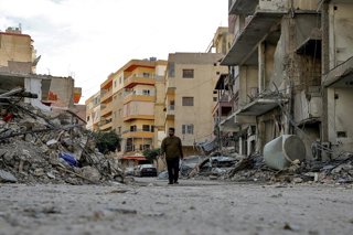 Archivo - Un hombre camina por una calle de Tiro, en Líbano, tras un ataque ejecutado por el Ejército de Israel (archivo)