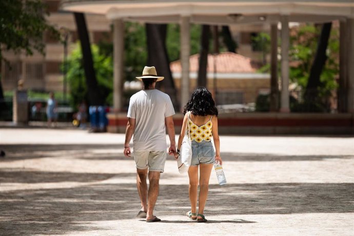 Archivo - Una pareja camina con una botella de agua.