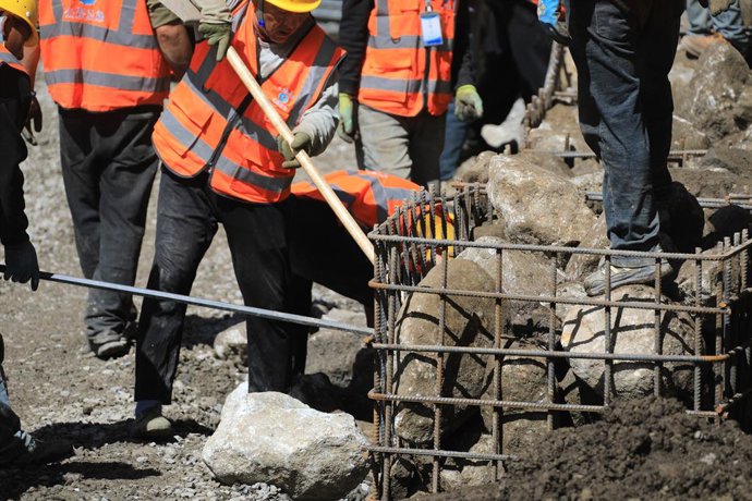 GYIRONG, 5 de setembro de 2026  -- Trabalhadores carregam pedras para o reforço da estrada na zona central mais afetada do Porto de Gyirong, atingido por um deslizamento de terra na Região Autônoma de Xizang, no sudoeste da China, em 5 de setembro de 2026