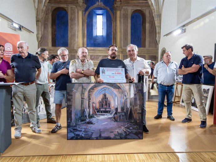 El artista Miguel Carlos Montesinos recibe un cheque de 2.000 euros por ganar el XV Concurso de Pintura Rápida 'Villa de Potes y Liébana'.