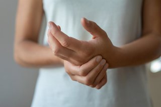 Archivo - Mujer tocándose la mano. Hormigueo, picor, dolor.