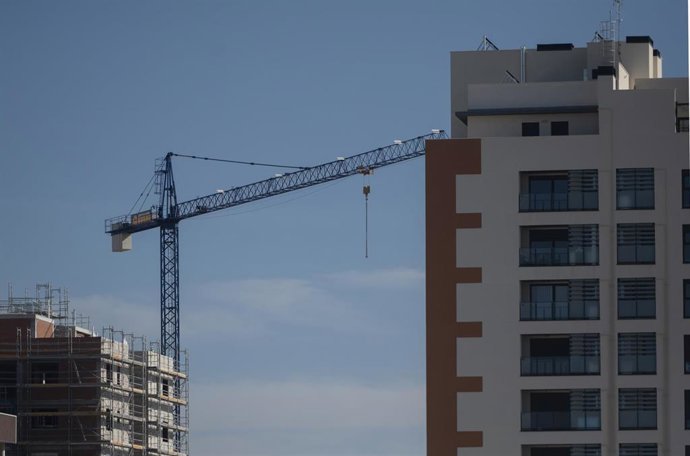 Archivo - Una grúa en una zona de construcción de viviendas