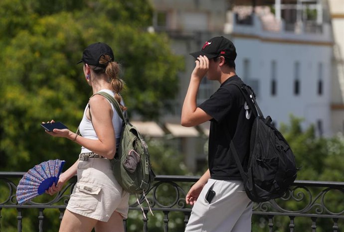 Turistas con sombrillas para protegerse del sol en la Plaza de España. A 03 de septiembre de 2026, en Sevilla (Andalucía, España). El mes de agosto en Andalucía se despide con un aumento de las temperaturas, de manera que sitúa el comienzo de septiembre p
