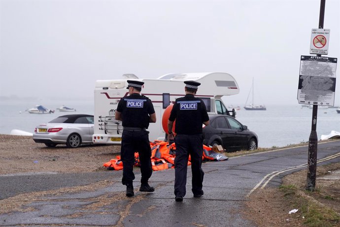 7 de setembro de 2026, Reino Unido, Portsmouth: Policiais passam por uma pilha de coletes salva-vidas descartados em Eastney Point, próximo à praia de Eastney, em Portsmouth, após um protesto ocorrido na noite passada, quando pessoas que se acredita serem