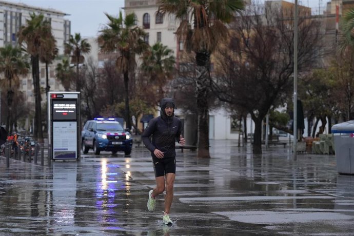 Archivo - Vecinos de Barcelona pasean bajo la lluvia en la playa de la Barceloneta durante el temporal, a 19 de enero de 2026, en Barcelona, Cataluña (España)  