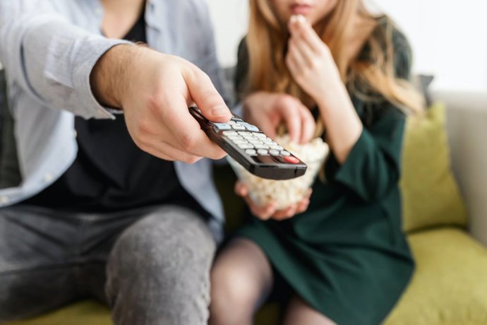 Archivo - Una persona sostiene un mando de la TV