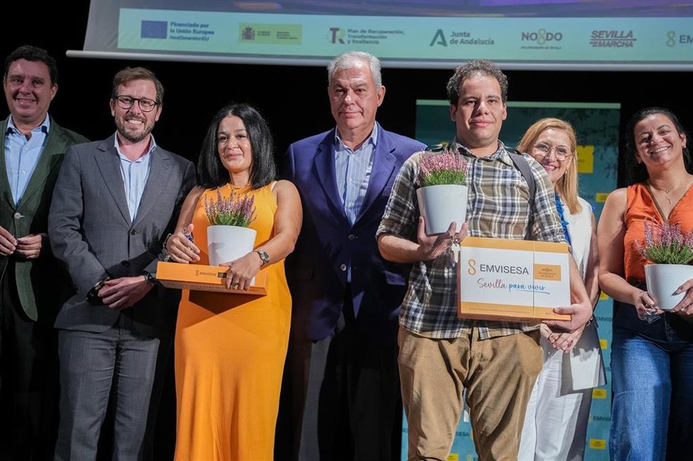 Foto de familia con algunos de los propietarios de las viviendas protegidas del Residencial Puerta Carmona, en regimen de alquiler, que se han levantado en el barrio sevillano de Palmas Altas, tras el simbólico acto de entrega de llaves