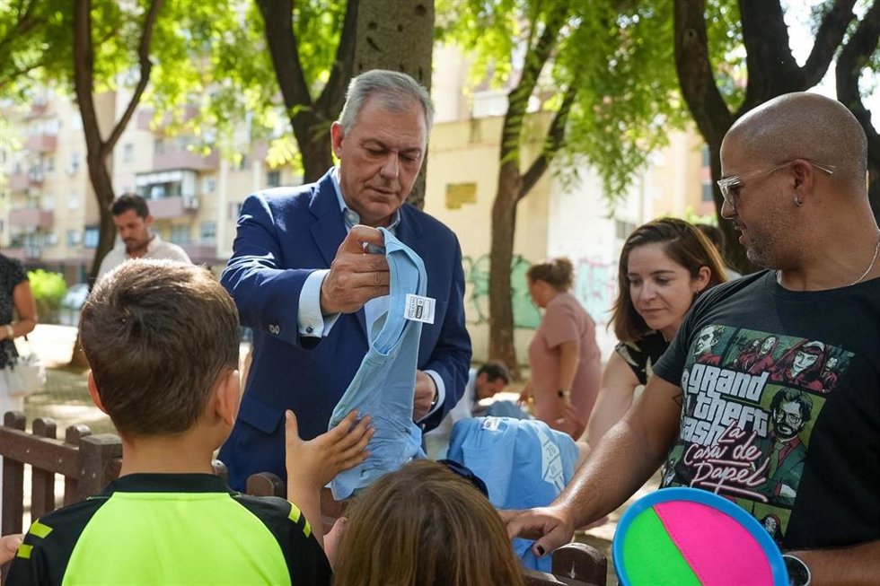 El alcalde entrega a varios menores camisetas diseñadas con ocasión de la llegada de La Vuelta a la capital andaluza