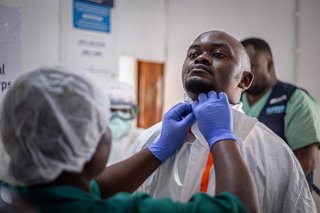 Un trabajador sanitario se coloca un traje de protección en un centro de tratamiento del ébola en la provincia de Kivu Norte, en la República Democrática del Congo. Imagen de archivo