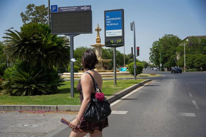 Archivo - Una mujer pasa junto a un termómetro en la avenida de El Cid que marca una temperatura superior a los 40ºC en pleno verano, en foto de archivo