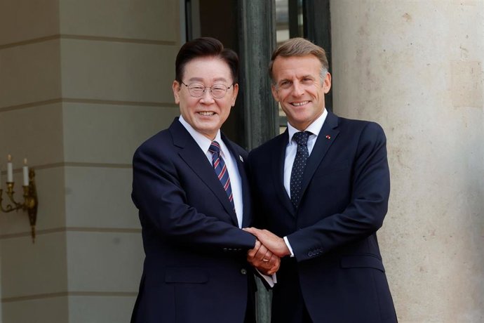 El presidente francés Emmanuel Macron (derecha) estrecha la mano del presidente surcoreano Lee Jae-myung en el Palacio del Elíseo en París, Francia