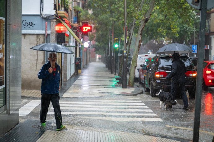 Archivo - Varias personas caminan bajo la lluvia, a 21 de septiembre de 2024, en Zaragoza, Aragón (España). Las precipitaciones han provocado afecciones en el tráfico y en el transporte público de la capital aragonesa. Además, la lluvia ha generado balsas
