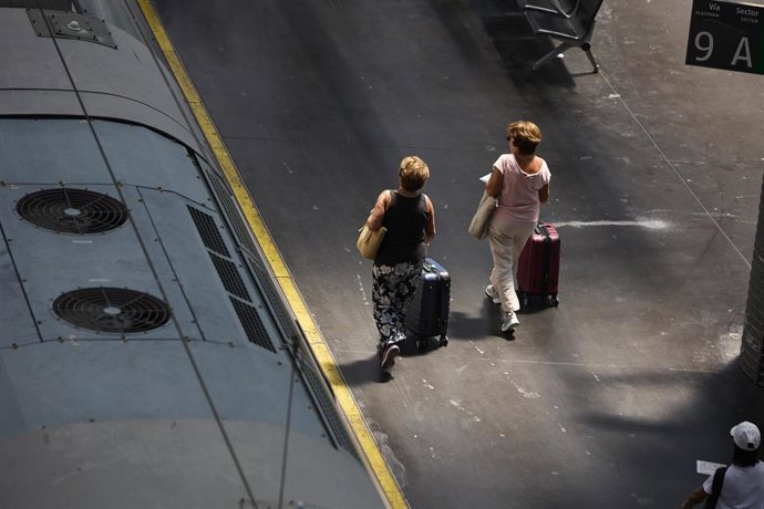 Archivo - Dos mujeres caminan por un andén de la estación de Ave Madrid - Puerta de Atocha, a 8 de agosto de 2022, en Madrid (España). 