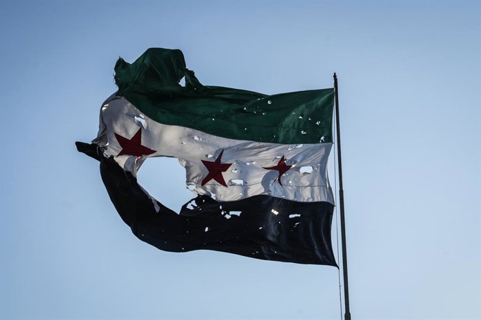 Archivo - Arquivo - 16 de julho de 2025, Síria, Damasco: Uma bandeira síria esfarrapada tremula na sede do Estado-Maior Geral sírio, após o local ter sido atingido por ataques aéreos israelenses em Damasco. Foto: Moawia Atrash/dpa