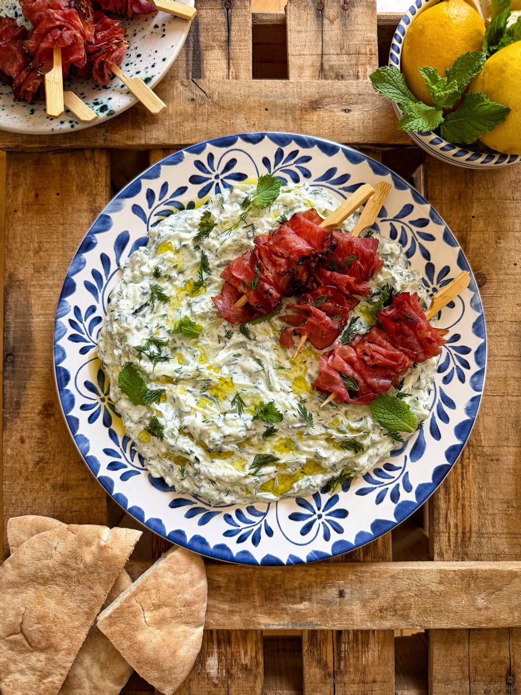 Crema de hierbas con brochetas y pan de pita.