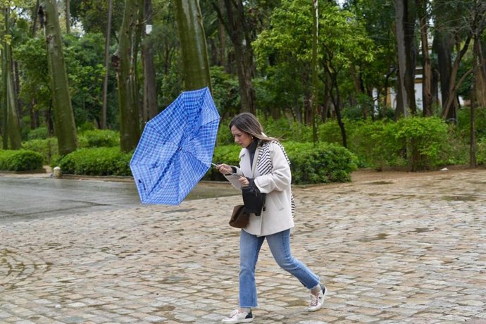 Archivo - Una mujer se protege de la lluvia. En imagen de archivo. 