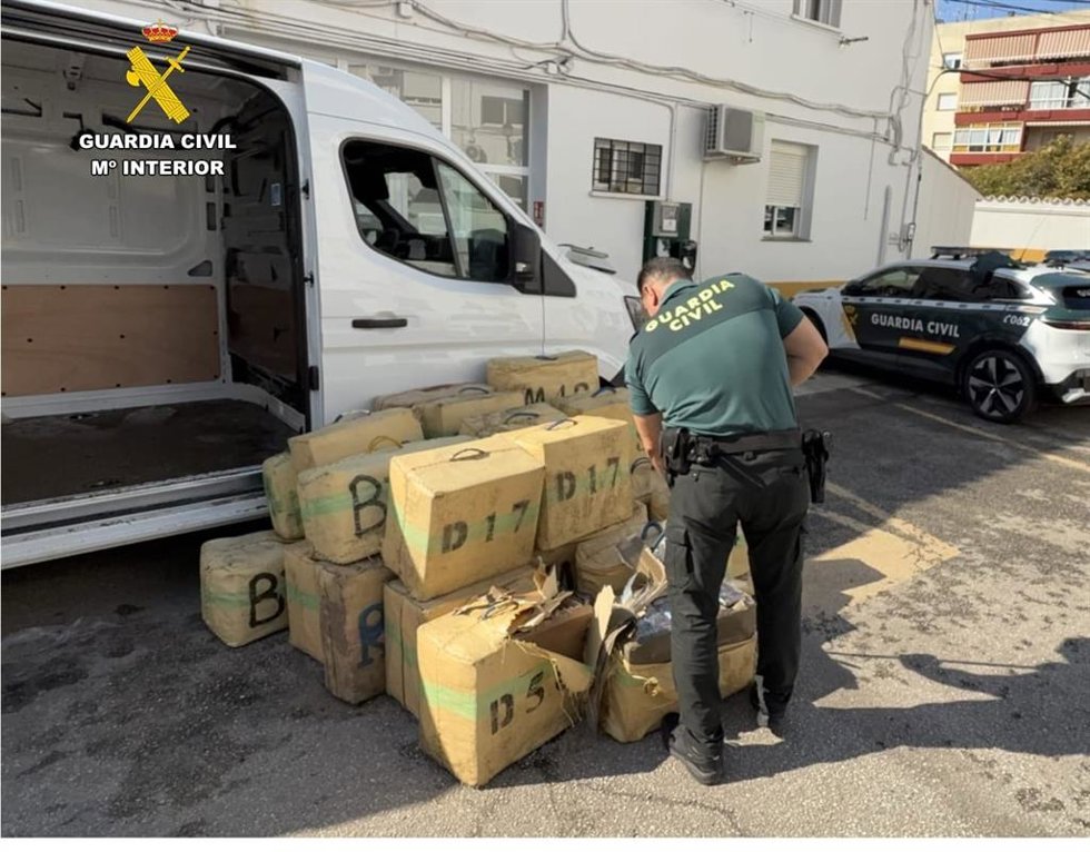 Imagen de un agente de la Guardia Civil junto a la droga incautada en Marbella (Málaga).