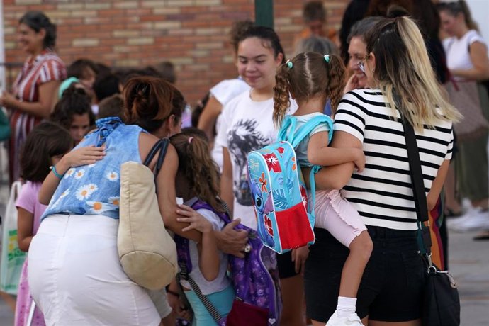 Archivo - Niños y padres hacen cola para entrar al colegio el primer día de clase tras la vacaciones de verano.
