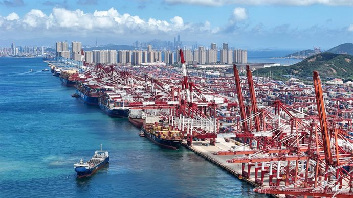 JINAN, 26 de agosto de 2026  -- Uma foto tirada por um drone em 25 de agosto de 2026 mostra navios porta-contêineres atracados no Terminal de Contêineres de Qianwan, no Porto de Qingdao, na província de Shandong, no leste da China. O volume de carga movim