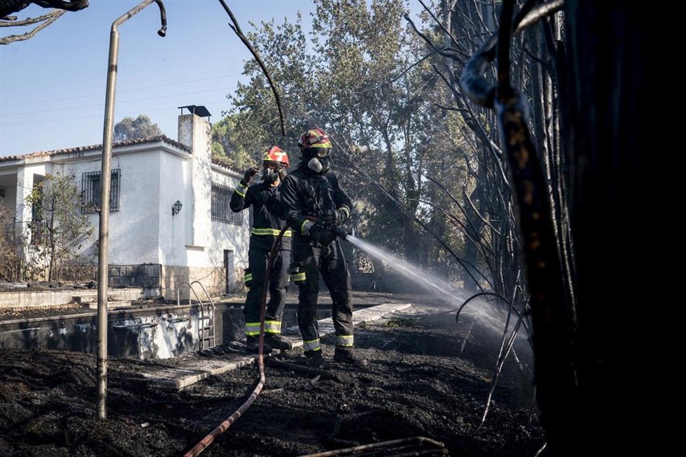 Varios bomberos colaboran en las labores de extinción, a 19 de agosto de 2026, en Aldea del Fresno, Madrid (España). U