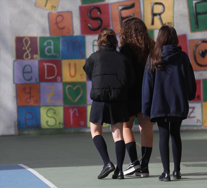 Archivo - Tres menores en el patio de un colegio.