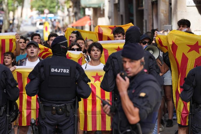 Decenas de personas de colectivos antifascistas tras el cordón policial durante una manifestación en protesta por el acto organizado por AC con motivo de la Diada, en el Fossar de les Moreres en Barcelona