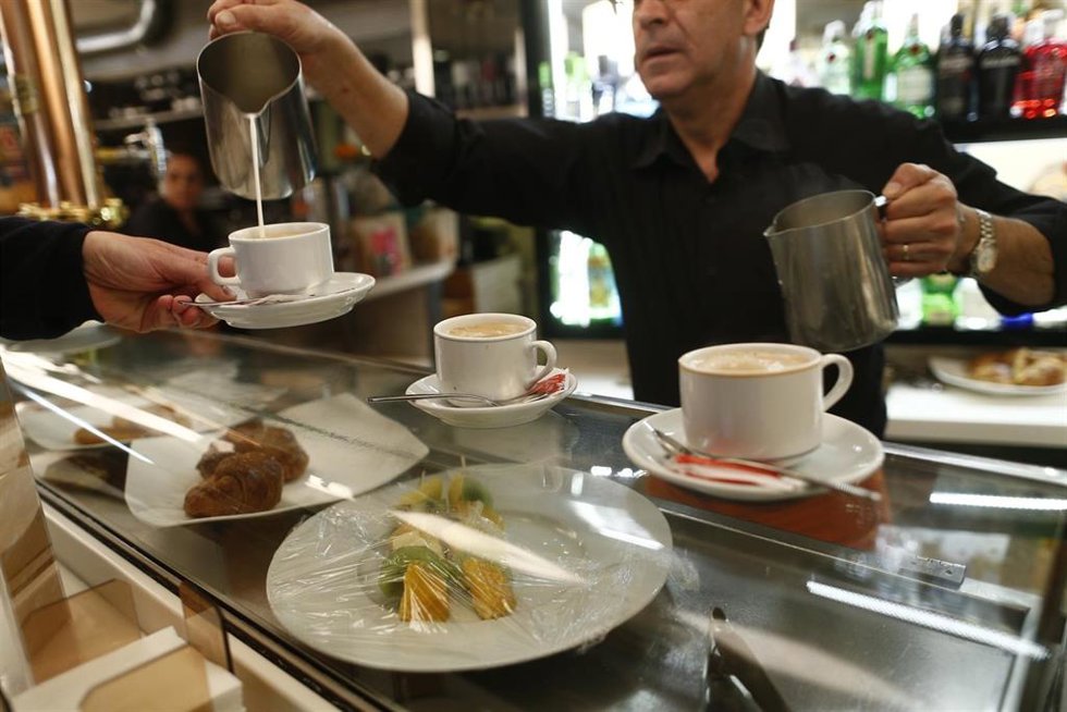 Archivo - Empleado sirviendo cafés en un bar.