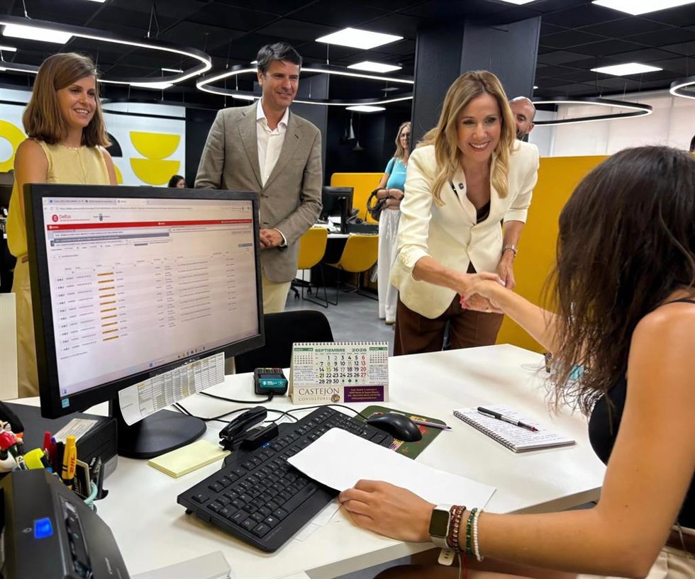 La consejera de Economía, Hacienda, Portavocía, Fondos Europeos y Transformación Digital, Marisa López Aragón, saluda durante su visita a una trabajadora de la oficina de la ATRM en Molina de Segura