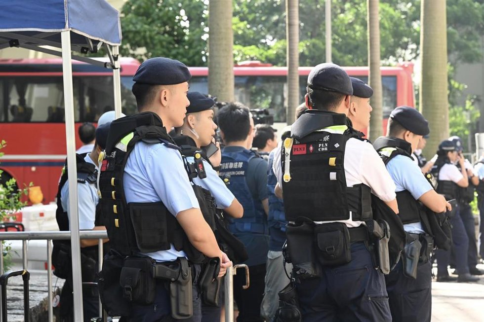 Agentes de las fuerzas de seguridad de Hong Kong desplegados frente a un tribunal antes de la lectura de las sentencias contra tres activistas por organizar actos en recuerdo de las víctimas de la masacre de Tiananmen