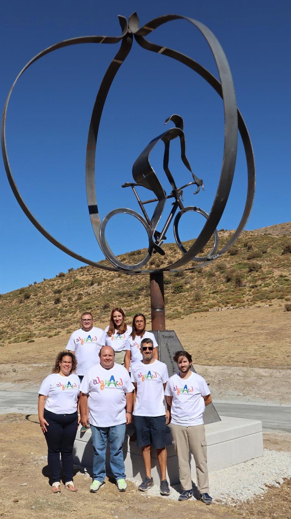 El equipo de Gobierno del Ayuntamiento de Güéjar Sierra y el escultor junto a la pieza monumental erirgida en Collado del Alguacil, final inédito de la etapa reina de La Vuelta Ciclista a España 2026 este sábado, 12 de septiembre, en tierras granadinas.