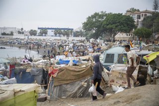 Varios inmigrantes acampados en la playa, a 5 de septiembre de 2026, en Ceuta (España). El Gobierno asume el control del puerto de Ceuta para la "atención humanitaria" de personas migrantes en carpas y otros espacios, según dispone una resolución del Mini