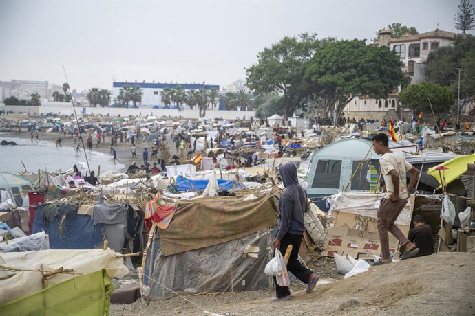 Vários imigrantes acampados na praia, em 5 de setembro de 2026, em Ceuta (Espanha). O governo assume o controle do porto de Ceuta para a “assistência humanitária” aos migrantes que se encontram em barracas e outros locais, conforme determina uma resolução