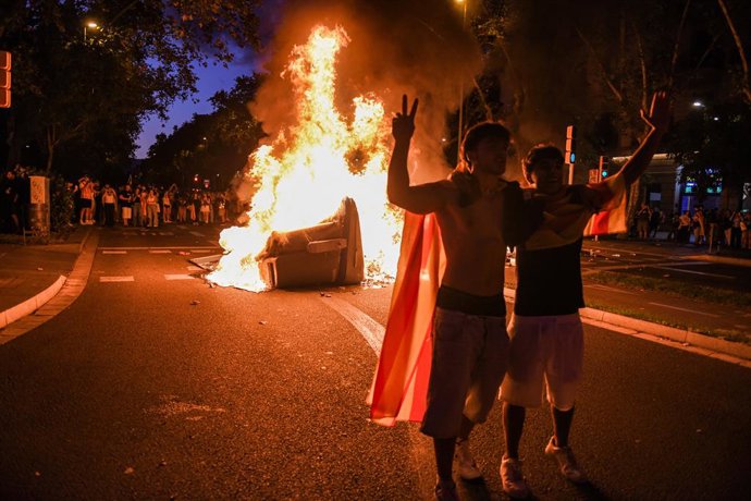 Activistes davant d'un contenidor en flames a Barcelona durant la Diada de Catalunya