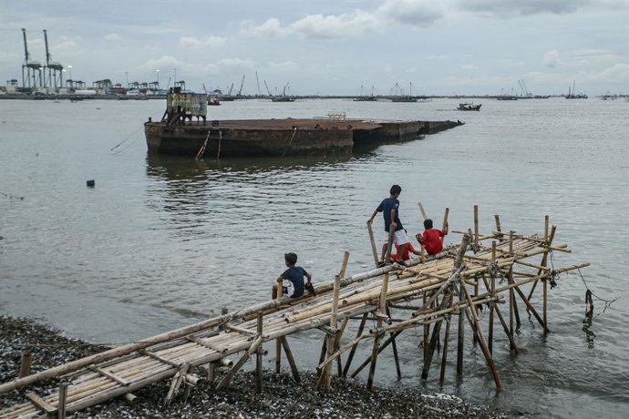 Archivo - January 3, 2026, Jakarta, Java, Indonesia: Children play near a shipwreck in Cilincing, Jakarta, Indonesia on January 3, 2026. The children continue to play in the water despite the large amount of waste and pollution in the area, which can caus