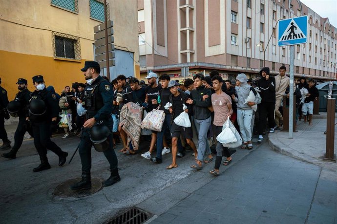 Centenares de personas se trasladan a pie durante el dispositivo de reubicación de migrantes hasta un nuevo centro temporal, en el barrio de Los Rosales, a 13 de septiembre de 2026, en Ceuta (España). El Ministerio de Inclusión, Seguridad Social y Migraci
