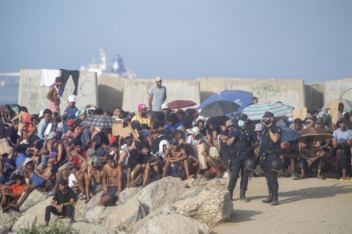 Dezenas de migrantes na praia de El Trampolín, em 7 de setembro de 2026, em Ceuta (Espanha).