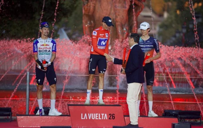 El presidente de la Junta de Andalucía, Juanma Moreno, saluda en el podio al ganador de La Vuelta Ciclista 2026, Enric Mas.