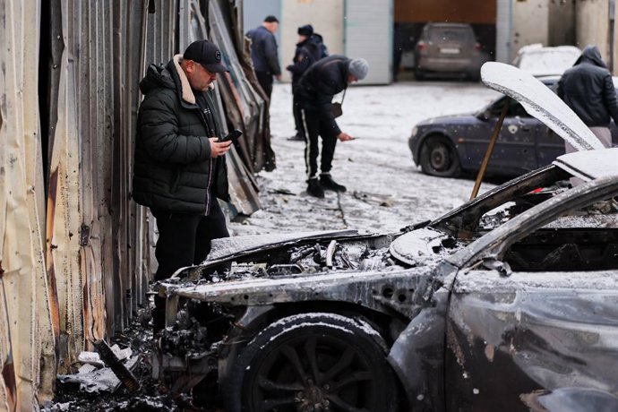 Archivo - Arquivo - 10 de janeiro de 2026, Rússia, Donetsk: Um homem é visto ao lado dos destroços de um carro após um ataque com drones pelas Forças Armadas da Ucrânia em Makeyevka, a leste de Donetsk. Foto: Dmitry Yagodkin/TASS via ZUMA Press/dpa