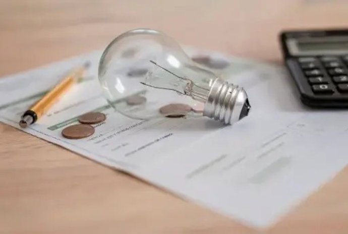 Imatge d'una bombeta i d'una factura de la llum per les despeses en electricitat.