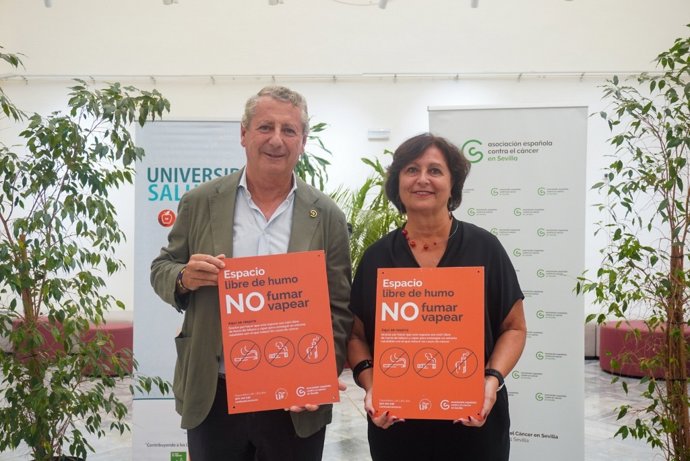 El presidente provincial de la Asociación Española Contra el Cáncer, Jesús Maza, y la vicerrectora de Bienestar, Salud, Diversidad e Igualdad de la Universidad de Sevilla, Rosario Antequera con la nueva señalética anti vapeadores