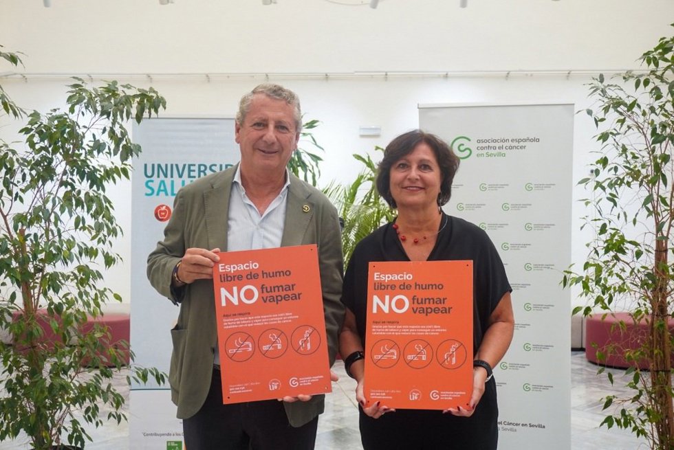 El presidente provincial de la Asociación Española Contra el Cáncer, Jesús Maza, y la vicerrectora de Bienestar, Salud, Diversidad e Igualdad de la Universidad de Sevilla, Rosario Antequera con la nueva señalética anti vapeadores