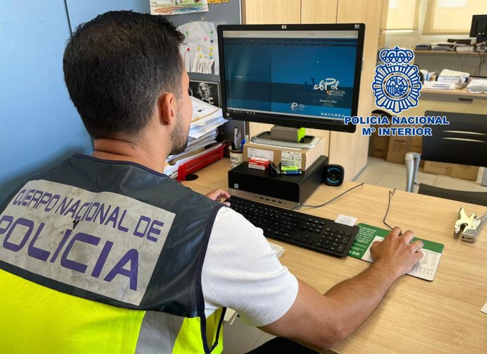Archivo - Arxiu - Un agent de la Policia Nacional enfront del seu ordinador.