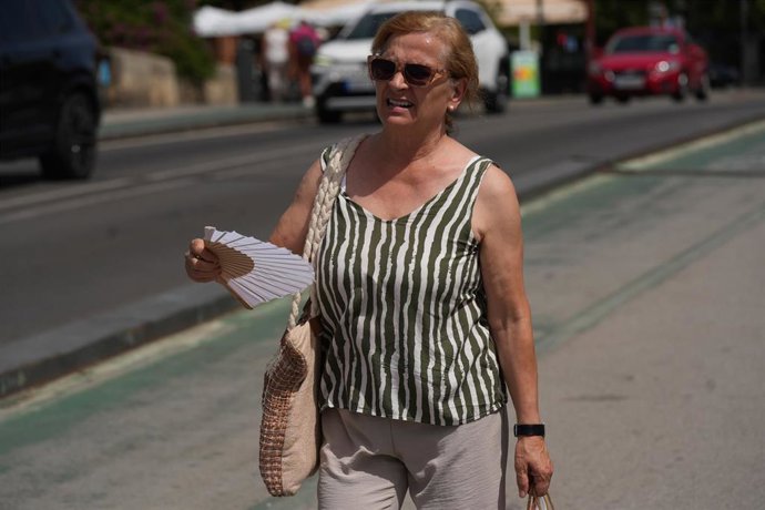Archivo - Una mujer con abanico durante una jornada de intenso calor en Sevilla.