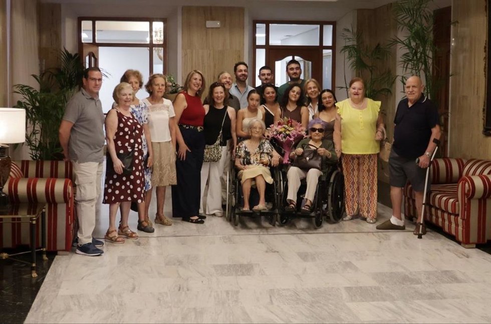 Inés Cuadrado, primera en silla de ruedas por la derecha, acompañada de su familia en la celebración de su 103 cumpleaños en el marco del programa 'Cordobeses Centenarios'.