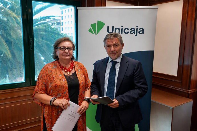 Firma de un acuerdo entre el director territorial de Málaga de Unicaja, Francisco José Reguera, y la presidenta de la Agrupación de Congregaciones, Hermandades y Cofradías de Gloria de Málaga, Victoria Eugenia Ribes.