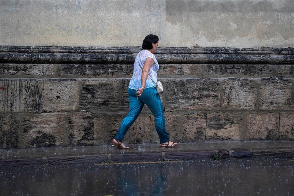 Archivo - Una mujer anda por la calle bajo la lluvia, en Valencia, Comunidad Valenciana (España). 