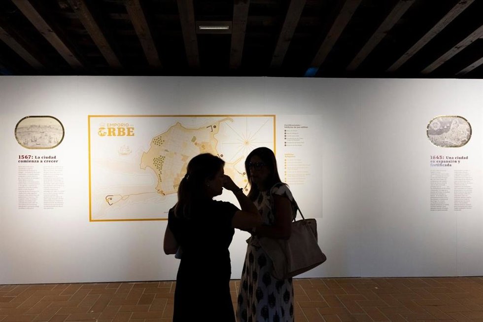 Dos personas contemplan uno de los planos de la exposición 'La ciudad que creció para el mundo', en el castillo de Santa Catalina de Cádiz.