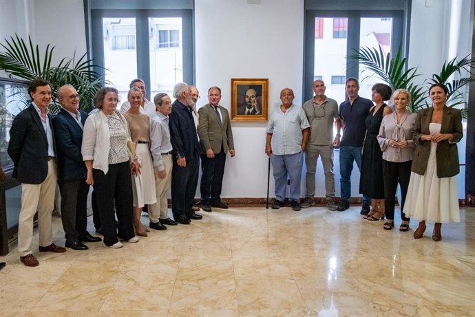 Foto de familia junto al retrato del Nobel moguereño Juan Ramón Jiménez, realizado por el pintor onubense Daniel Vázquez Díaz.